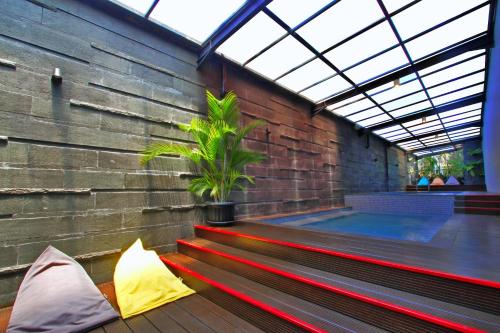 a room with a bench and a swimming pool at Hemangini Hotel Bandung in Bandung