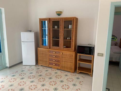 kuchnia z drewnianą szafką i lodówką w obiekcie House sole - Unique Panorama w mieście Lipari