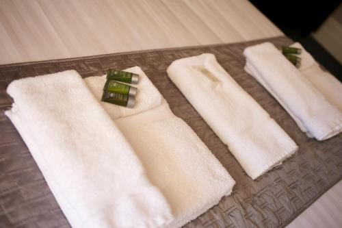 a group of white towels on a bed at Grand Hotel in Newcastle