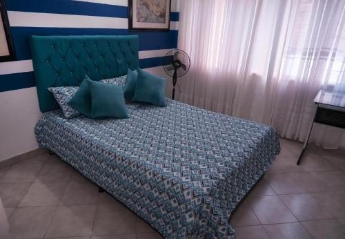 1 dormitorio con 1 cama con cabecero verde en Casa La Palma Habitación Cielo, en Medellín