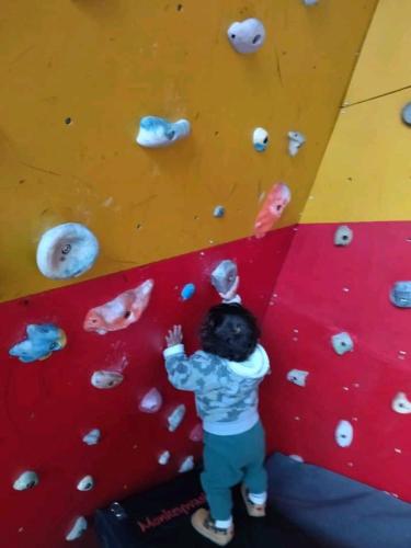 a young boy standing on a climbing wall at Monkeywasi Climbing Hostel in Huaraz