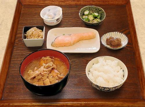 a wooden tray topped with bowls of food and rice at Hotel Trend Numazu Ekimae in Numazu