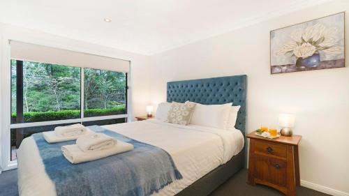 a bedroom with a large bed and a window at Alba Gardens in Bundanoon