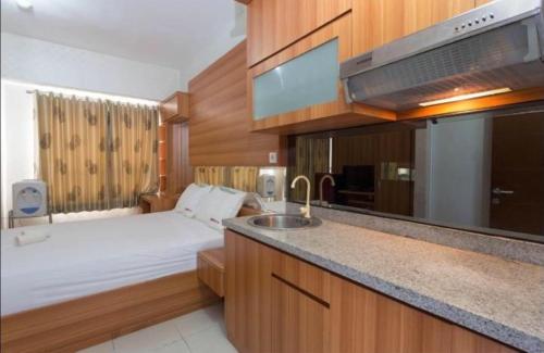 kuchnia z łóżkiem i umywalką w pokoju w obiekcie Apartemen Taman Melati Margonda by Winroom w mieście Kukusan