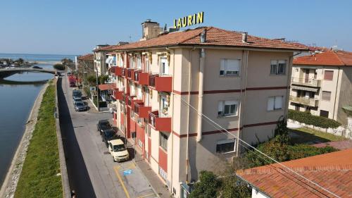 un bâtiment avec un panneau en haut, à côté d'une rue dans l'établissement Hotel Laurin, à Lido di Camaiore