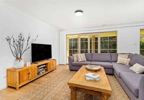 a living room with a couch and a tv at Beach Haven in Shoalhaven Heads