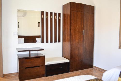 a dressing room with a mirror and a wooden cabinet at VILLA MARIA PETRA in Wadi Musa