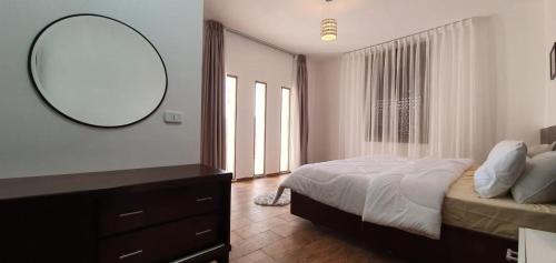 a bedroom with a bed and a mirror and a dresser at VILLA MARIA PETRA in Wadi Musa