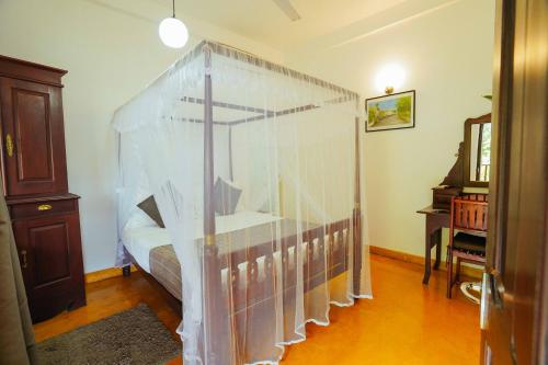 a bedroom with a canopy bed in a room at Fort Dew Guest House in Galle