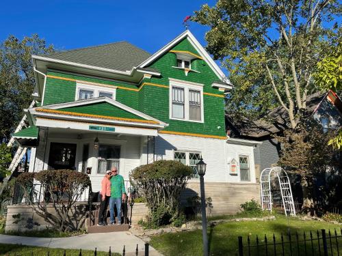 two people standing in front of a green house at The Avanti Houses in South Bend
