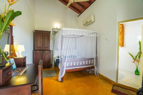 a bedroom with a crib with a white curtain at Fort Dew Guest House in Galle