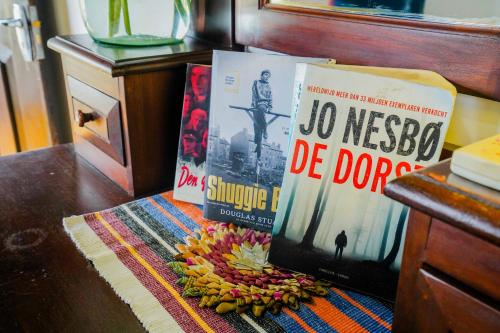 a pile of books on a table with a pile of bananas at Fort Dew Guest House in Galle