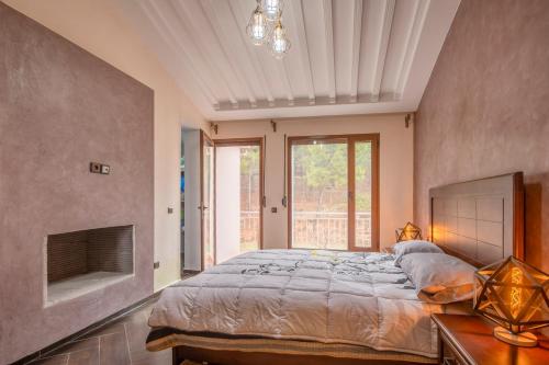 een slaapkamer met een groot bed en een open haard bij Chalet Asmoun 2 in Imouzzer Kandar