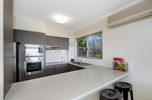 a kitchen with stainless steel appliances and a counter top at Bali Hai Apartments Noosa in Noosa Heads