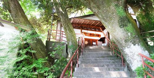 a set of stairs leading to a building with a tree at Kappa Tengoku in Hakone