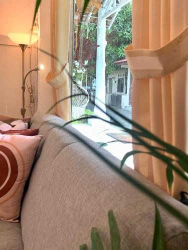 a couch sitting in a room with a window at Roemah Renjana Yogyakarta in Timuran