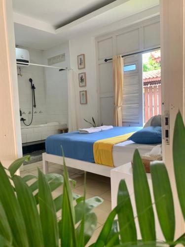 a bedroom with a bed and a shower at Roemah Renjana Yogyakarta in Timuran