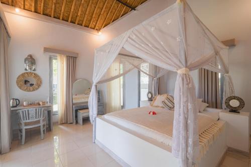 a bedroom with a canopy bed and a desk at Salt Resort & Spa in Amed