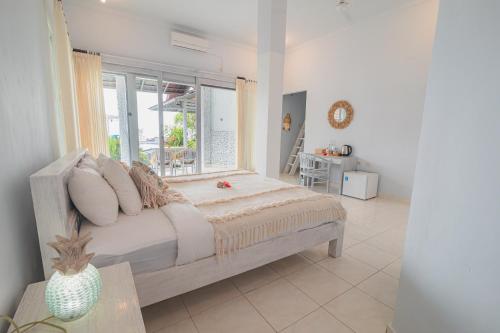 a bedroom with a bed with a window and a table at Salt Resort & Spa in Amed