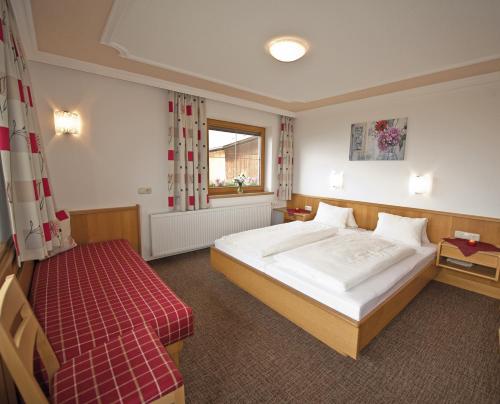 ein Schlafzimmer mit einem großen weißen Bett und einem Fenster in der Unterkunft Gästehaus Bergruh in Tux