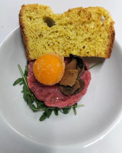 a plate with a sandwich and a slice of bread at Rifugio Caltena in Fiera di Primiero