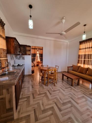 a kitchen and living room with a table and a couch at Grand Station Residence (Rose) in Seeduwa