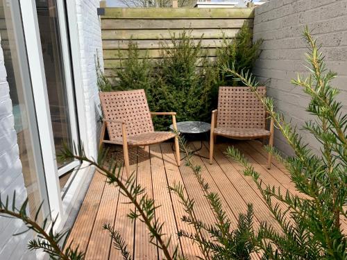 two chairs and a table on a wooden deck at Hotel Janssen in Valkenburg