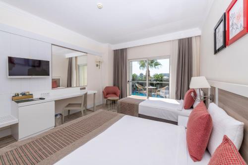 シダにあるPort River Hotel&Spaのベッドとデスクが備わるホテルルームです。