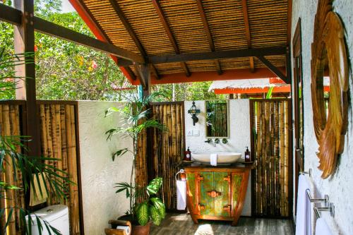 an outdoor bathroom with a sink and a mirror at Burudika Bungalows in Selong Belanak