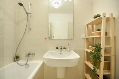 a white bathroom with a sink and a mirror at VACATION FEEL - 2BR Apartment with Terrace & Private Parking in Baneasa in Bucharest