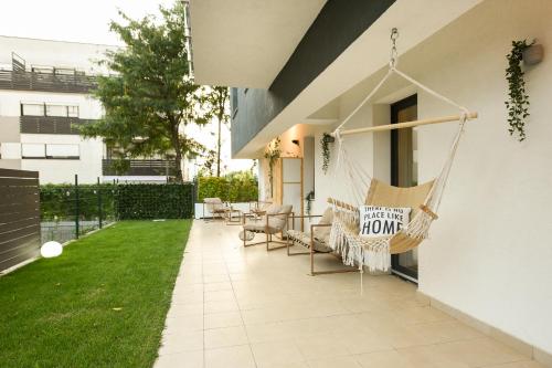 a house with a porch with a hammock hanging from the window at VACATION FEEL - 2BR Apartment with Terrace & Private Parking in Baneasa in Bucharest