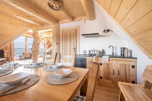 a kitchen and dining room with a table and chairs at Dom Tatrzański Ewa Deluxe in Kościelisko