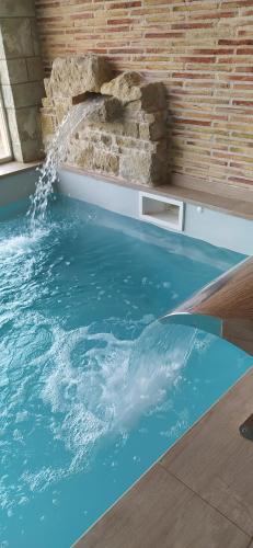a swimming pool with a waterfall in a house at Hotel & Spa Can Josep in Bot