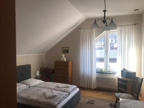 1 dormitorio con cama, ventana y vestidor en Apartament u Gabi, en Chojnice