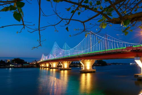 a bridge over the water at night at Sleepbox Hostel Suratthani in Suratthani