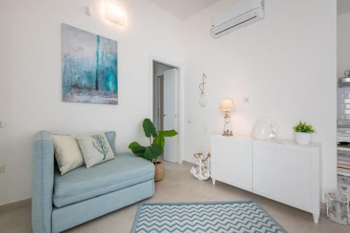 a living room with a blue couch and a white cabinet at La casa dei naviganti in Villasimius