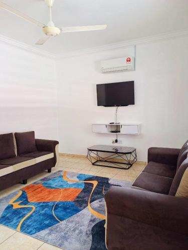 a living room with two couches and a tv at MZ homestay in Shah Alam