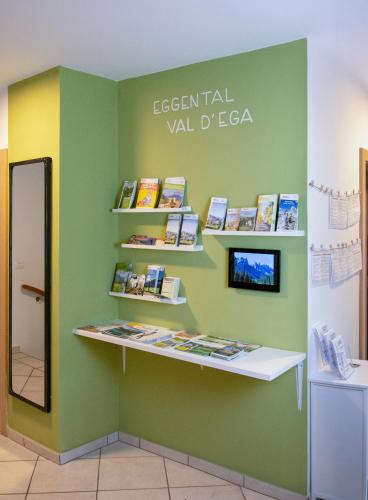 una mensola con libri su una parete verde di Villa Gottfried Appartment a Ega