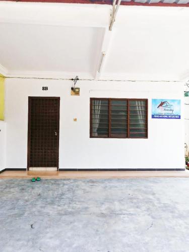 a white wall with a door and two windows at MZ homestay in Shah Alam