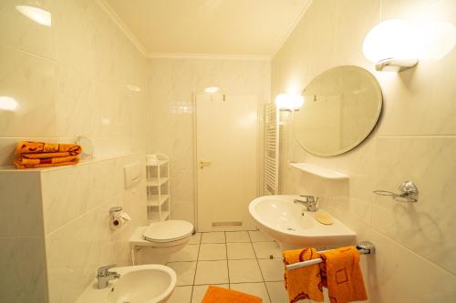 Un baño con lavabo, inodoro y espejo. en Haus Nordstrand Vereinsalle 21WHG 2 6, en Büsum