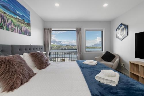 - une chambre avec un grand lit et une grande fenêtre dans l'établissement Exciting Queenstown, à Queenstown
