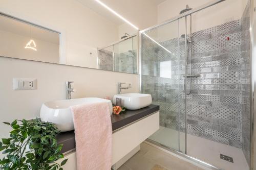 a bathroom with a sink and a glass shower at La Casa dei sognatori in Villasimius