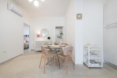 a white dining room with a table and chairs at La Casa dei sognatori in Villasimius
