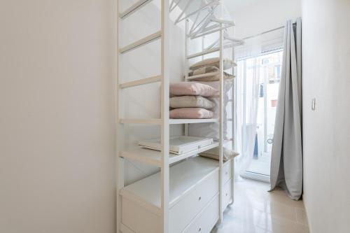 a white closet with white shelves and pillows at La Casa dei sognatori in Villasimius