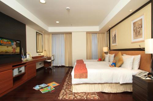 a hotel room with a large bed and a television at Somerset Greenways Chennai in Chennai