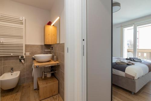 a bathroom with a bed and a sink and a mirror at Cristallo apartment - ristrutturato nuovo centro Aprica in Aprica