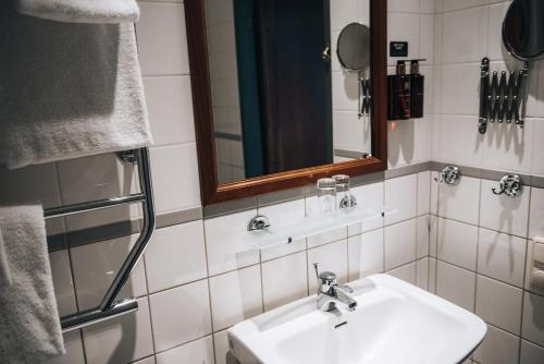 a bathroom with a sink and a mirror and towels at Clarion Hotel Wisby in Visby