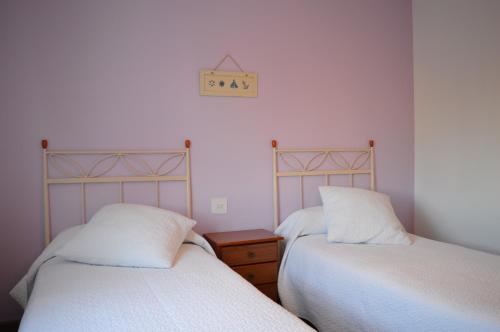 1 dormitorio con 2 camas y reloj en la pared en Huertas de la Fuente, en Cella