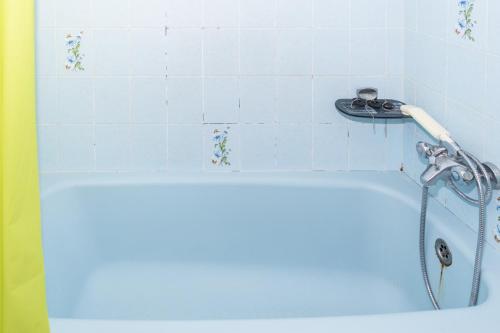 a bathroom with a blue tub with a shower at Arensol Esc-A, 13º-51 in Cullera