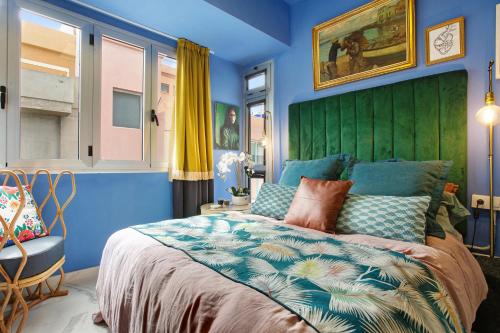 Dormitorio azul con cama grande y cabecero verde en Blue moon, en Las Palmas de Gran Canaria